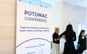 Three people stand in front of the conference poster