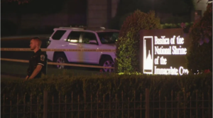 Police officer and caution tape are seen in front of the sign for the Basilica of the National Shrine of the Immaculate Conception